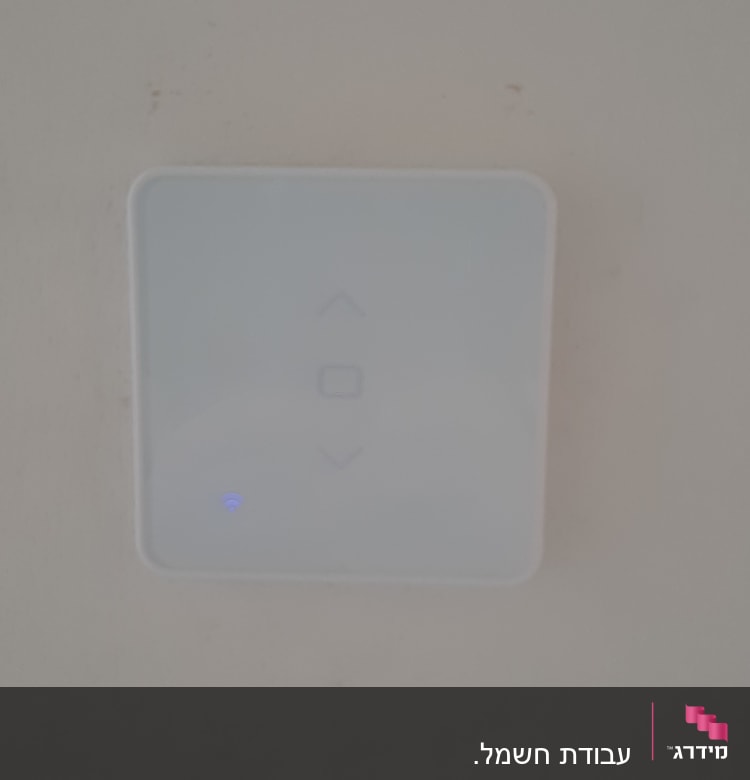 מתג חשמלי חכם עם חיווי כחול על קיר